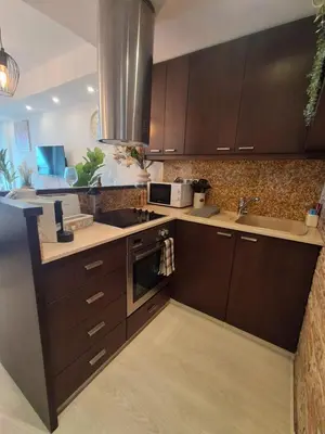 a kitchen with brown cabinets and a sink and a microwave at Lazuli Sea View Beachfront Studio Nr 305 in Larnaka