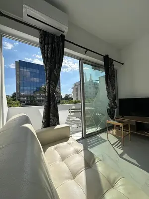 a living room with a couch and a large window at Seaside Studio in Limassol
