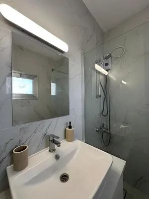 a white bathroom with a sink and a shower at Seaside Studio in Limassol