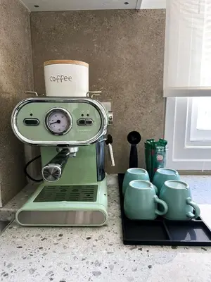 a green coffee machine sitting on a counter with mugs at Nicosia city center 1BDR apartment in Nicosia