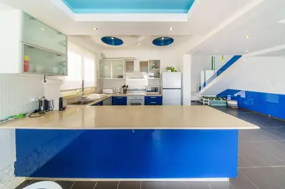 a large kitchen with blue cabinets and a blue island at Villa Waves in Mazotos