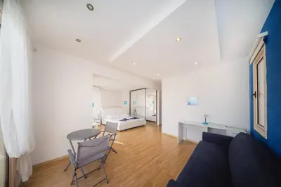a living room with a couch and a table and a bed at Villa Waves in Mazotos