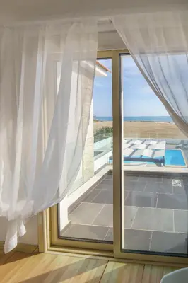 a room with a window with a view of the ocean at Villa Waves in Mazotos