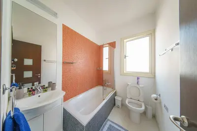 a bathroom with a tub and a toilet and a sink at Villa Waves in Mazotos