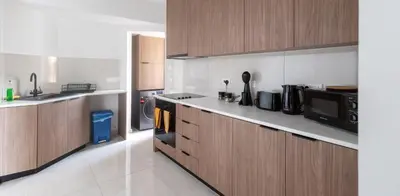 a kitchen with wooden cabinets and a microwave at Maestro Family - Apartment in Larnaka