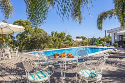 a patio with a table and chairs next to a swimming pool at Marina Heights Villa in Protaras