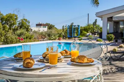 a table with plates of food and glasses of orange juice at Marina Heights Villa in Protaras