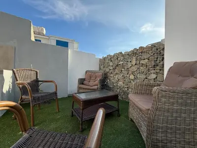 a patio with chairs and a couch and a wall at Onar Exclusive Studio Suite in Voroklini