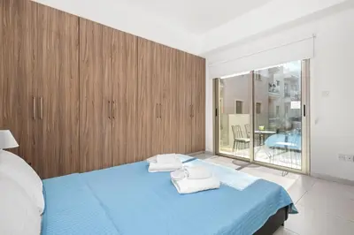 a bedroom with a blue bed with towels on it at Downtown 1 Bedroom City Apartment in Larnaka
