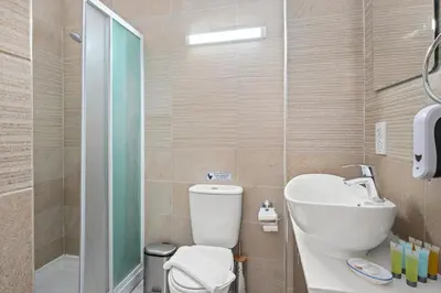 a bathroom with a toilet and a sink and a shower at Downtown 1 Bedroom City Apartment in Larnaka
