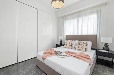 a bedroom with a large bed with white walls at Noir Luxury Residences by Nomads in Limassol