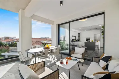 a living room with a balcony with a table and chairs at Noir Luxury Residences by Nomads in Limassol