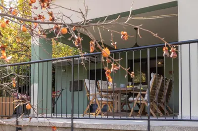 a patio with a table and chairs on a balcony at Maison du Mont in Kalopanayiotis