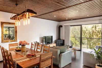 a dining room with a table and a couch at Maison du Mont in Kalopanayiotis