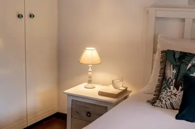 a bed with a lamp and a book on a night stand at Maison du Mont in Kalopanayiotis