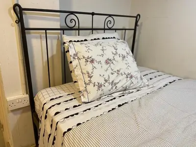a bed with a black frame and a pillow on it at Archangelos Studio in Strovolos