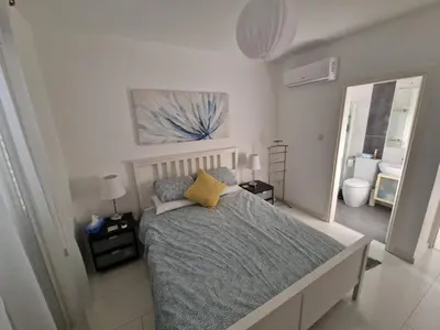 a bedroom with a large bed and a bathroom at Sunshine Villa Kapparis in Paralimni