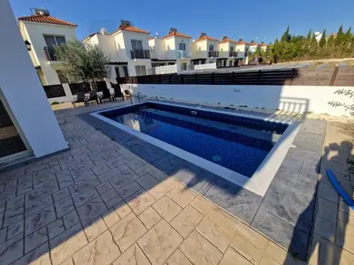 a swimming pool in front of a house at Sunshine Villa Kapparis in Paralimni