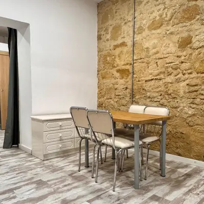 a table and chairs in a room with a stone wall at Central Nicosia 1BR House in the Walled City in Nicosia