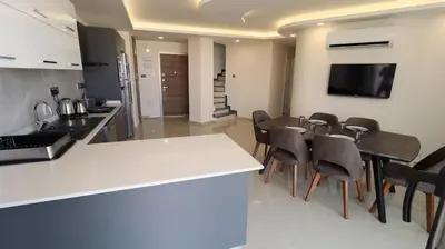 a kitchen and dining room with a table and chairs at Girne Merkezde Geniş Teraslı Havuzlu Daire in Alsancak