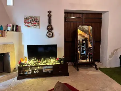 a living room with a television and a table with christmas lights at Charming 3-Bedroom Cottage in Heart of Vasa Koilaniou in Vasa Kilaniou