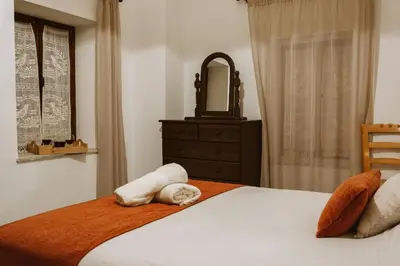 a bedroom with a bed with towels and a mirror at Charming 3-Bedroom Cottage in Heart of Vasa Koilaniou in Vasa Kilaniou