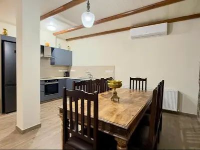 a kitchen and dining room with a wooden table and chairs at To Petrino 2 Apartment -Authentic Comfort in the Heart of Kalopanayiotis in Kalopanayiotis