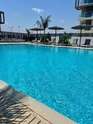 a large blue swimming pool with chairs and umbrellas at Fall In Paradise in Paralimni