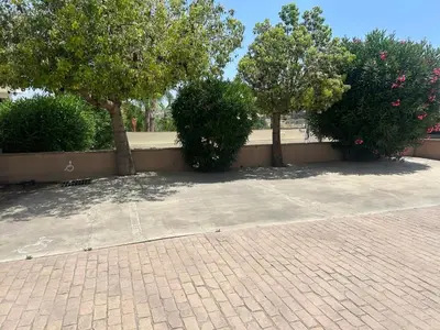 a brick walkway with three trees and a wall at Sea View Valley Retreat in Voroklini