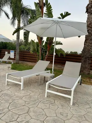 two chairs and an umbrella on a patio at Sea View Valley Retreat in Voroklini