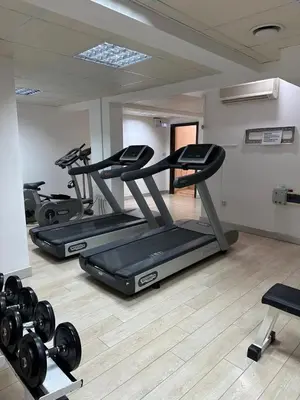 a gym with three treadmills and weights in a room at Sea View Valley Retreat in Voroklini