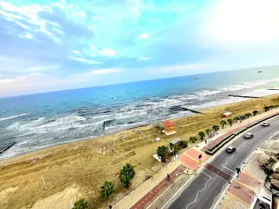 a view of a beach with a road and the ocean at Breathtaking Beachfront Apartment in Makenzy in Larnaka