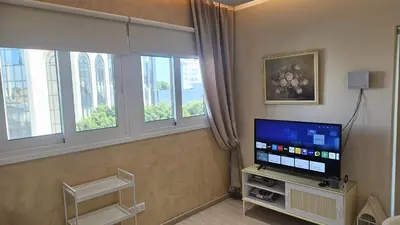 a living room with a television and two windows at STAY Fantasia Central Suite in Nicosia