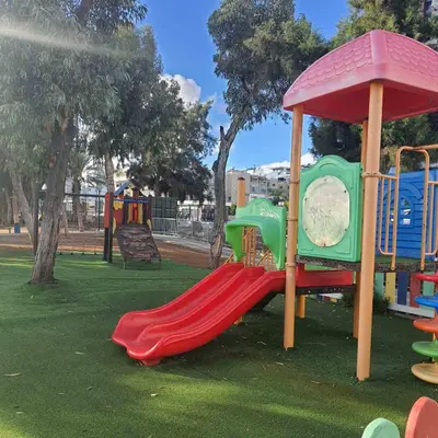 a playground with a red slide in a park at Amato Beach in Limassol