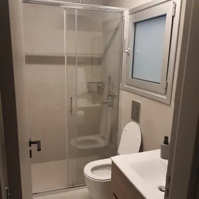 a bathroom with a shower with a toilet and a sink at Amato Beach in Limassol
