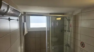 a bathroom with a glass shower with a window at STAY Vintage Central Suite in Nicosia