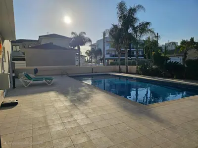 a swimming pool with a bench next to a house at Horizon View 2 in Kiti