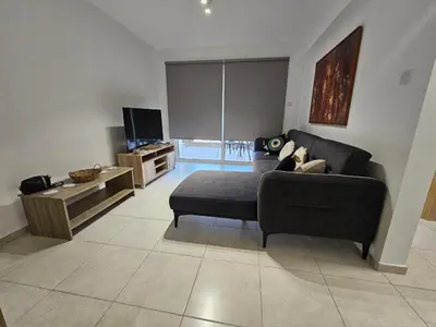 a living room with a couch and a tv at Horizon View 2 in Kiti