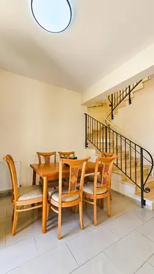 a dining room with a wooden table and chairs at Townbeach Villa with Private Pool in Voroklini