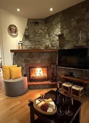 a living room with a fireplace and a table with food at Kyperounta Heights - Breathtaking View in Kyperounda