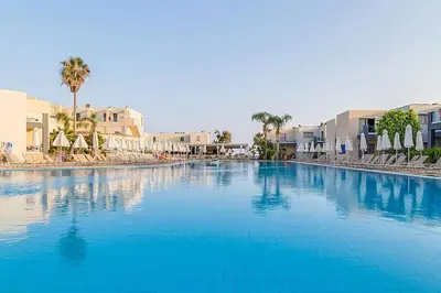 a large swimming pool with blue water in a resort at Electra Beach Holiday Village in Ayia Napa
