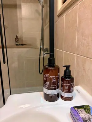 two bottles of soap sitting on top of a bathroom sink at The Lodge Kampi by Thea Suites