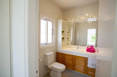 a bathroom with a toilet and a sink and a mirror at Meneou Beachfront Villa Sunset in Pervolia