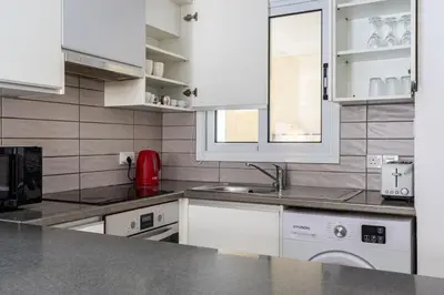 a kitchen with white cabinets and a sink at Levante - 2-BR Apt & Terrace in Larnaca in Larnaka