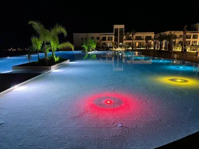a large swimming pool at night with a red light at CoveDream Studio Sun Valley Esentepe in Aglantzia