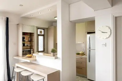 a kitchen with a table and a clock on a wall at Mackenzie Beachfront Suite in Larnaka