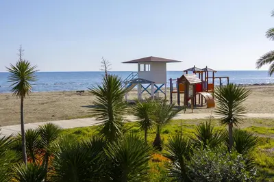 a playground on the beach next to the ocean at Mackenzie Beachfront Suite in Larnaka
