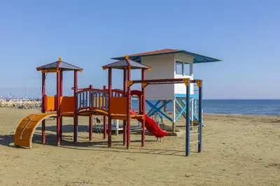a playground on the beach next to the ocean at Mackenzie Beachfront Suite in Larnaka