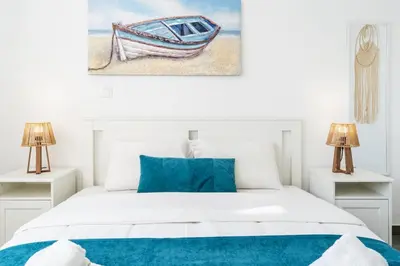 a bedroom with a bed and a painting of a boat at Azoria - Stylish 1-BR Apartment & Balcony in Kiti in Kiti