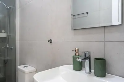 a bathroom with a sink and a shower and a toilet at Azoria - Stylish 1-BR Apartment & Balcony in Kiti in Kiti